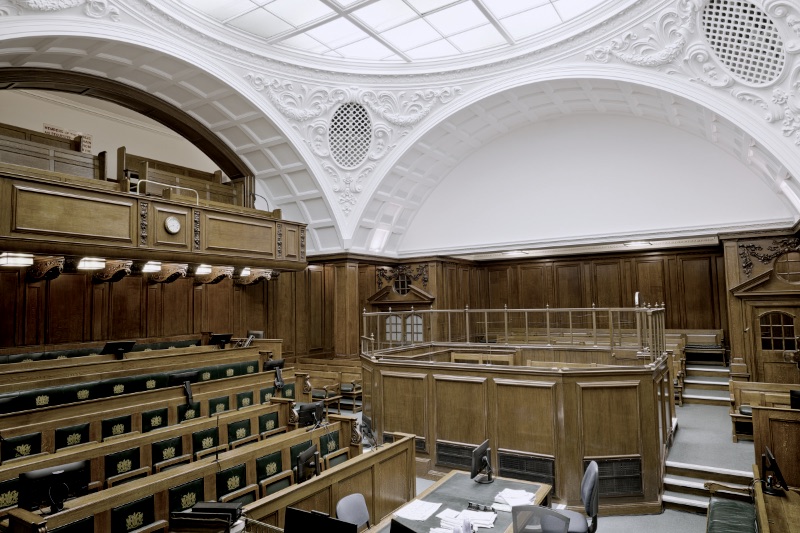 An empty courtroom interior seen from the public benches