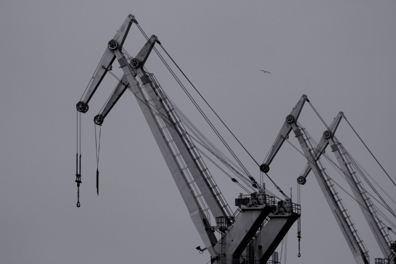 A single container crane arm against an overcast sky